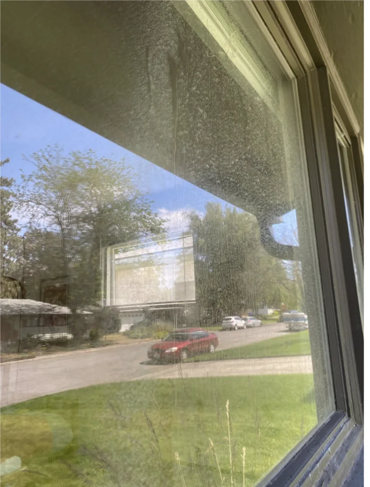 Residential window with visible spots and buildup before hard water review