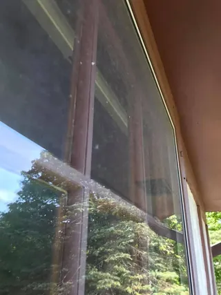 Exterior residential window with visible dirt, spots, and buildup before cleaning