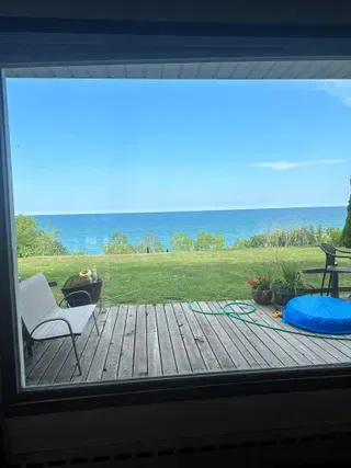 A clean window looking out over a bright deck and water view after window washing